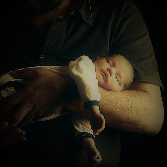 Newborn baby and his father's hand