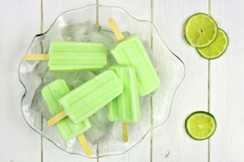 Frozen lime yogurt popsicles in an ice filled bowl