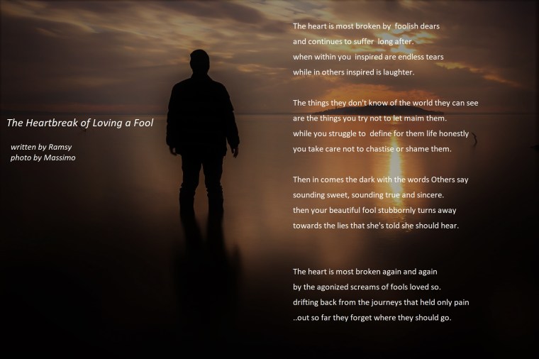 Long exposure shot of a silhouette of a man in water in front of a sunset