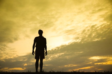 Silhouette of a man sitdown with so sad in the sunset.