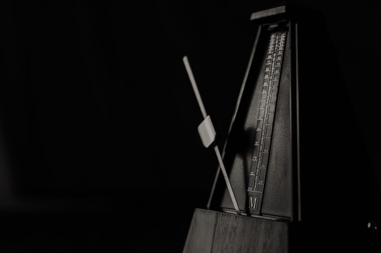 Vintage metronome, on a dark background.
