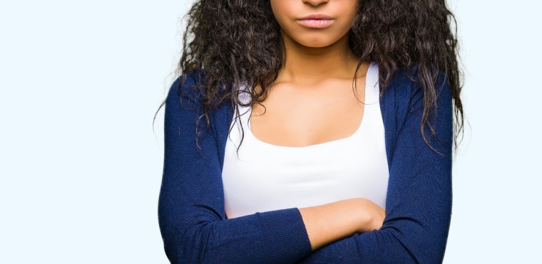 Young beautiful girl with curly hair wearing fashion sunglasses skeptic and nervous, disapproving expression on face with crossed arms. Negative person.