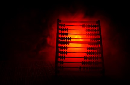 Chinese calculator with colorful beads on fire orange smoke dark background . Concept photo of business, child ,education , teaching ,learning,