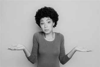 I dont care. Portrait of doubtful negative curly hair afro american girl cant choose answer solve trouble shrug shoulders hold hands hesitate wear beautiful outfit isolated blue color background