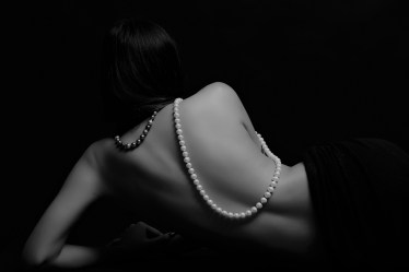 Portrait of beautiful nude long straight black hair woman with pearl necklace
