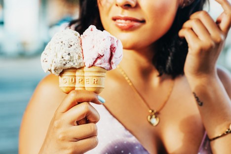 Double cone ice cream holding by young beautiful woman, Stracciatella and Bubble Gum taste