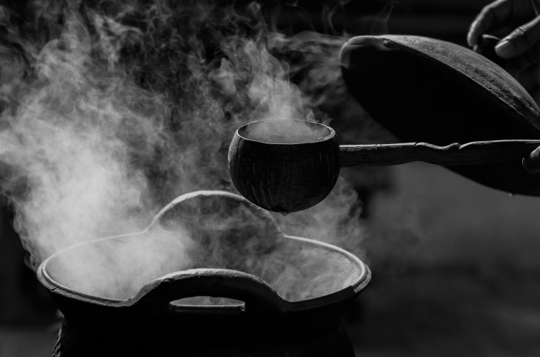 Handle spoon dipper over the smoke from traditional clay hot pot