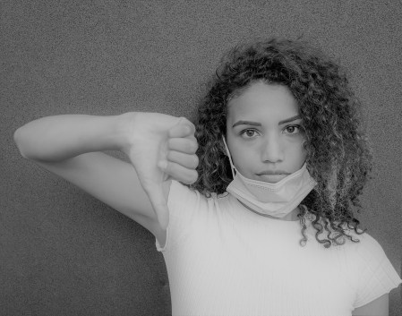 A beautiful African American woman with a misplaced face mask