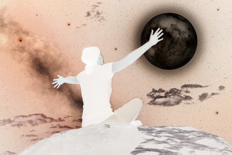 woman sitting and raising arms in the moonlight