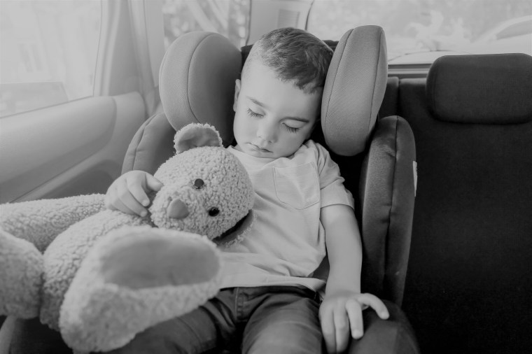 Baby boy sleeping on car safety seat